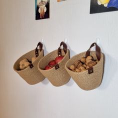 three baskets filled with nuts hanging on the wall