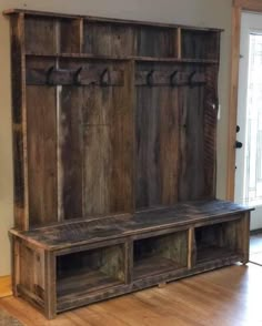 a large wooden bench sitting on top of a hard wood floor next to a door