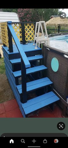 a blue stair case next to a swimming pool in the back yard with an above ground hot tub