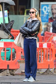 a woman wearing headphones standing on the street