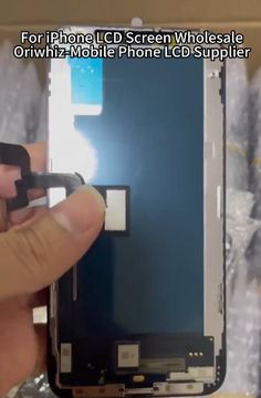 someone is holding the display screen with their thumb and opening it to remove it from the phone