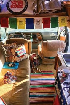 the interior of a vehicle with colorful rugs on the floor and couches in the back