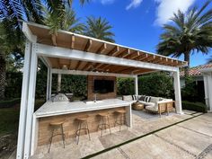 an outdoor kitchen and bar with palm trees in the background