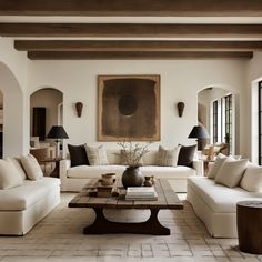 a living room filled with white couches and tables