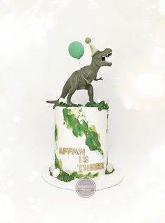 a birthday cake with a dinosaur on top