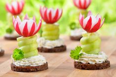 small appetizers are arranged on a wooden table in the shape of flowers and leaves