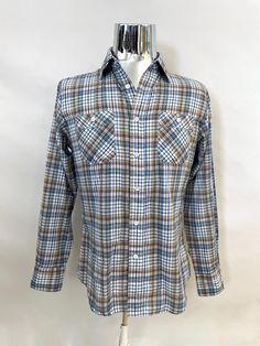 "Vintage Men's 80's Saturday's, White, Plaid, Button Down, Shirt (S) This Men's Shirt comes in white Cotton/Polyester Blend fabric and has a Plaid Print in White, Blue, Orange, Green and Black, with Long Sleeves with Single Wrist Button Closure, Seven front Button Closure, Two Chest Pockets with Single Button Closure, and Collar. 35% Cotton 65% Polyester *This Shirt is in Excellent Condition. Size: (S) (Tag Size: M) Chest: 42\" Length: 29\" Sleeve Length: 24 1/2\" (outside) 20\" (inside armpit t Retro Button-up Flannel Shirt, Retro Cotton Shirt With Snap Buttons, Retro Cotton Flannel Shirt With Button Closure, Retro Collared Flannel Shirt With Button Closure, Mens 80s, White Plaid, Women's Plaid Shirt, Vintage Men, Button Downs