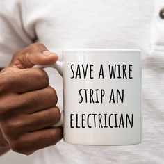 a person holding a coffee mug that says save a wire strip an electrician