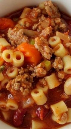 a white bowl filled with pasta and meat soup