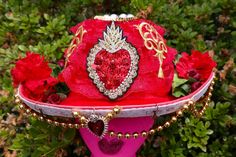 Red cowgirl hat with beaded red, gold and black heart on the front. Red lace all around, with gold accents and lots of red flowers filling the back. Around the brim is white lace, gold beaded strings, a red heart pendant and star beads. Red Cowgirl Hat, Red Heart Pendant, Star Beads, Handmade Things, Cowgirl Hat, Cow Girl, Cowgirl Hats, Bead Stringing, Heart On