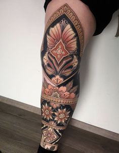 a woman's leg with tattoos on it and flowers in the middle of her legs