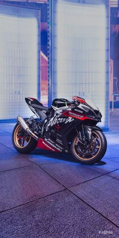 a black and red motorcycle parked in front of a building