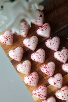 heart shaped marshmallows on a cutting board with sprinkled red and white icing