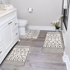 a bathroom with two rugs on the floor