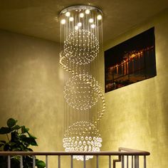 a chandelier hanging from the ceiling in a room with a potted plant