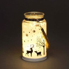 a lighted jar with deer and snowflakes on it