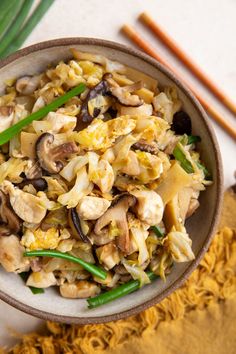 a bowl filled with rice and vegetables next to chopsticks