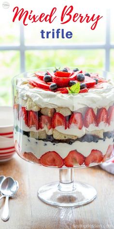 mixed berry trifle in a glass dish on a wooden table