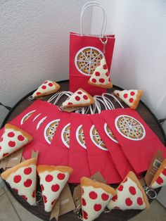 a table topped with slices of pizza on top of red paper bags and small pieces of pizza