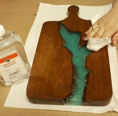 a wooden cutting board sitting on top of a table next to a bottle of water