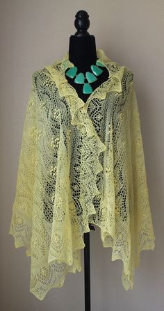 a yellow lace shawl on a black mannequin headdress and necklace