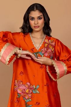 Sundown orange kurta with floral patchwork embroidery and scallop sleeves. Paired with embroidered pant.
Component: 2
Pattern: Embroidered
Type Of Work: Nakshi, triangle lace, sequin, cutdana, kisti stone, resham work
Neckline: V Neck
Sleeve Type: Scallop
Fabric: Chanderi Silk
Color: Orange
Other Details: 
Scallop detail
Patchwork embroidery
Occasion: Mehendi and Haldi - Aza Fashions Festive Orange Kurta With Floral Embroidery, Eid Orange Kurta With Floral Embroidery, Orange Floral Embroidered Kurta For Eid, Orange Floral Embroidery Kurta For Eid, Festive Orange Floral Embroidery Set, Spring Orange Kurta With Floral Embroidery, Orange Resham Embroidery Sets For Spring, Orange Sets With Resham Embroidery For Spring, Traditional Orange Sets With Floral Embroidery