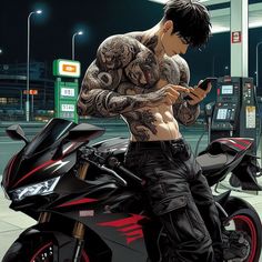 a man sitting on top of a motorcycle next to a gas pump holding a cell phone