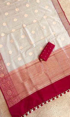 Gray Banarasi Katan Silk Saree with Motifs and Contrast Pink Zari Border| Traditional silk Beige saree | pattu saree| Bollywood Style A Banarasi saree is a robust canvas where a weaver's unmatched craftsmanship, imagination, and creativity comes to life! His dexterous hands beautifully blend the years of skills and experience to craft 6 yards of wearable art for the global woman of today's times. This saree is resplendent with all the elements of a rich Banarasi saree. The highlight of the drape is the color combination with zari work. The Motifs add a shimmering touch to the eye-catching shade making this saree a timeless classic. The zari drenched pallu and borders enveloped in zari add to the grandeur of this classic drape. *Note: This is a handwoven saree and there may be slight incons Dola Silk Traditional Wear With Border For Puja, Dola Silk Saree With Border For Puja, White Banarasi Silk Dupatta With Border, Banarasi Silk Traditional Wear With Border For Wedding, Wedding Banarasi Silk Blouse Piece With Border, Tissue Silk Traditional Wear With Border For Eid, Eid Tissue Silk Dupatta With Border, Wedding Paithani Silk Dupatta With Border, Wedding Traditional Wear With Banarasi Silk And Border