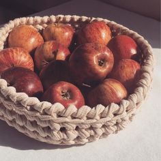 a basket filled with apples sitting on top of a table