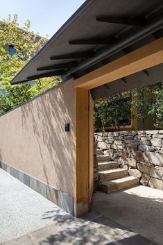 an outdoor area with stone walls and steps leading up to the outside wall, which is covered by a black awning