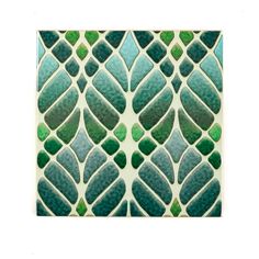 an art deco tile with green leaves on it's back side and white background