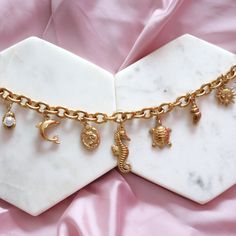 The Seashell Charm Bracelet is a must-have for beach and summer lovers. Crafted from 18k gold-plated stainless steel, this durable charm bracelet features an array of beach-themed pendants, including seashells, starfish, mermaids, and sun motifs. Tarnish-resistant and built to last, it's the perfect accessory for coastal adventures. * 18k Gold Stainless Steel * Tarnish Resistant * 8mm Chain * Standard 7" Length * With Love from Texas Cheap Silver Charm Bracelet For Beach, Metal Oyster Bracelet For Beach, Beach Charm Bracelet With Lobster Clasp, Beach Metal Bracelets With Charms, Metal Charm Bracelets For Beach, H2o Just Add Water, Best Friend Bracelet, Charm Bracelet Gold, Friend Bracelet