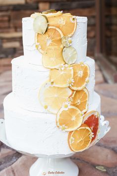 a white cake with oranges and lemon slices on it