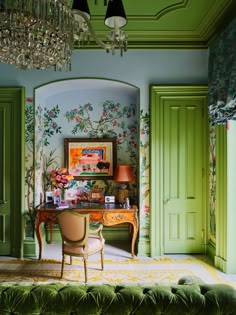 a room with green walls and floral wallpaper on the walls, an ornate chandelier hangs from the ceiling