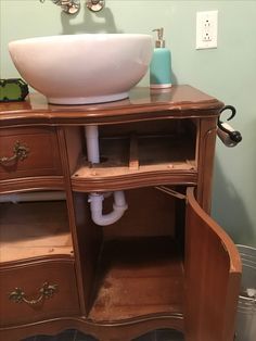 a bathroom sink sitting on top of a wooden cabinet