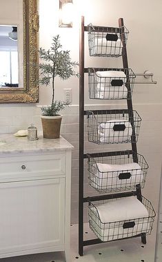 four baskets are stacked on top of each other in front of a mirror and sink