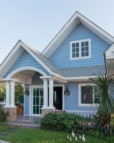 a blue house with white trim and columns