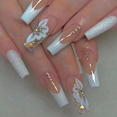 a woman's hands with white and gold nail designs