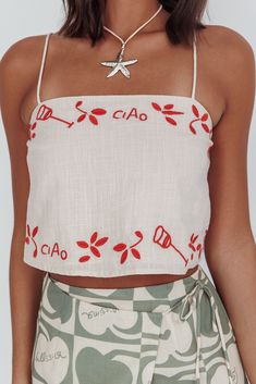 Linen-look cami top Adjustable spaghetti straps Red Italian inspired embroidery Cropped length Straight neckline Fully lined Float through your weekend in our super cute Sorrento Summer top. We are obsessed with its Italian-inspired embroidery detail and breezy crop length. It's perfect for Sunny weekends strolling your fave vintage flea markets with your BFF. Team it with its matching pants and slides for a look we are crushing on. MODEL INFO Model is wearing size XS Height: 5'8"" Bust: 31.0"" Sewing Outfits, Vintage Flea Market, Cowboy Chic, Yellow Bridesmaid Dresses, Embroidered Crop Tops, Yellow Bridesmaids, Purple Bridesmaids, Red Bridesmaids, Green Bridesmaid