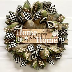 a wreath with the words home sweet home on it and checkered bows hanging from the front