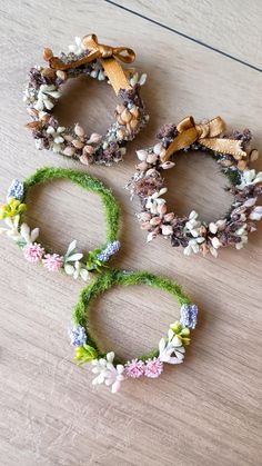 three wreaths with flowers on them sitting on a table