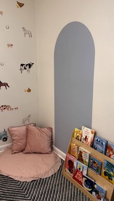 a child's room with a bed, bookshelf and wall decals