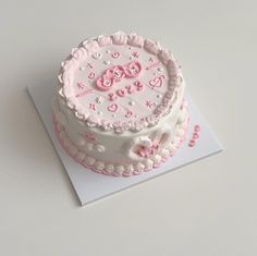 a pink and white cake on top of a card with the number 50 on it