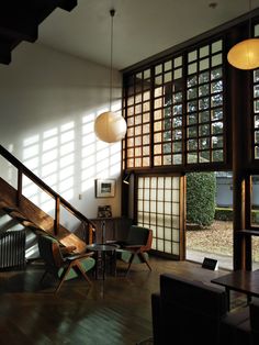 the sun shines through the windows in this living room with wood floors and chairs