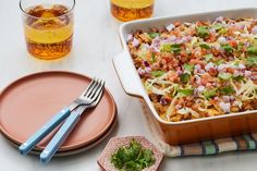 a casserole dish with coleslaw, onions and cilantro on the side