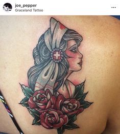 a woman's back tattoo with flowers and a cross on her shoulder, done by joe pepper at graceland tattoo