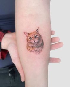 a cat tattoo on the left forearm and right arm, with an orange cat's face