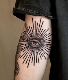 a person with a tattoo on their arm that has an all seeing eye in it