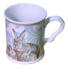 a blue and white coffee mug with an image of two rabbits on it