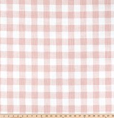 a pink and white checkered fabric with a ruler in front of the plaid pattern